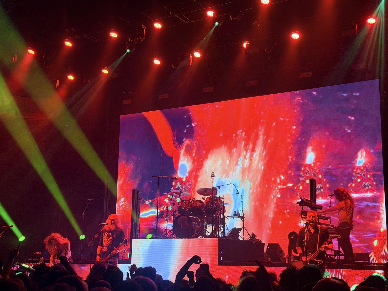 Mastodon performing at the Hollywood Palladium with green stage lights and a red video wall