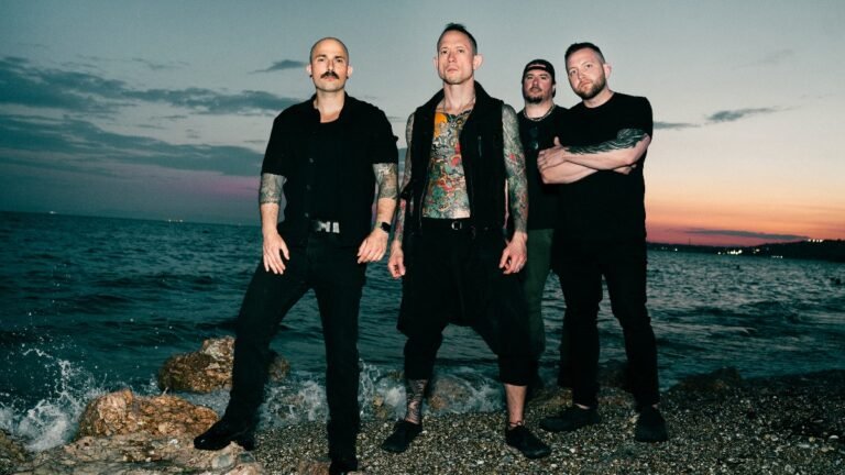 Trivium band press photo on a rocky shoreline at dusk, 2026